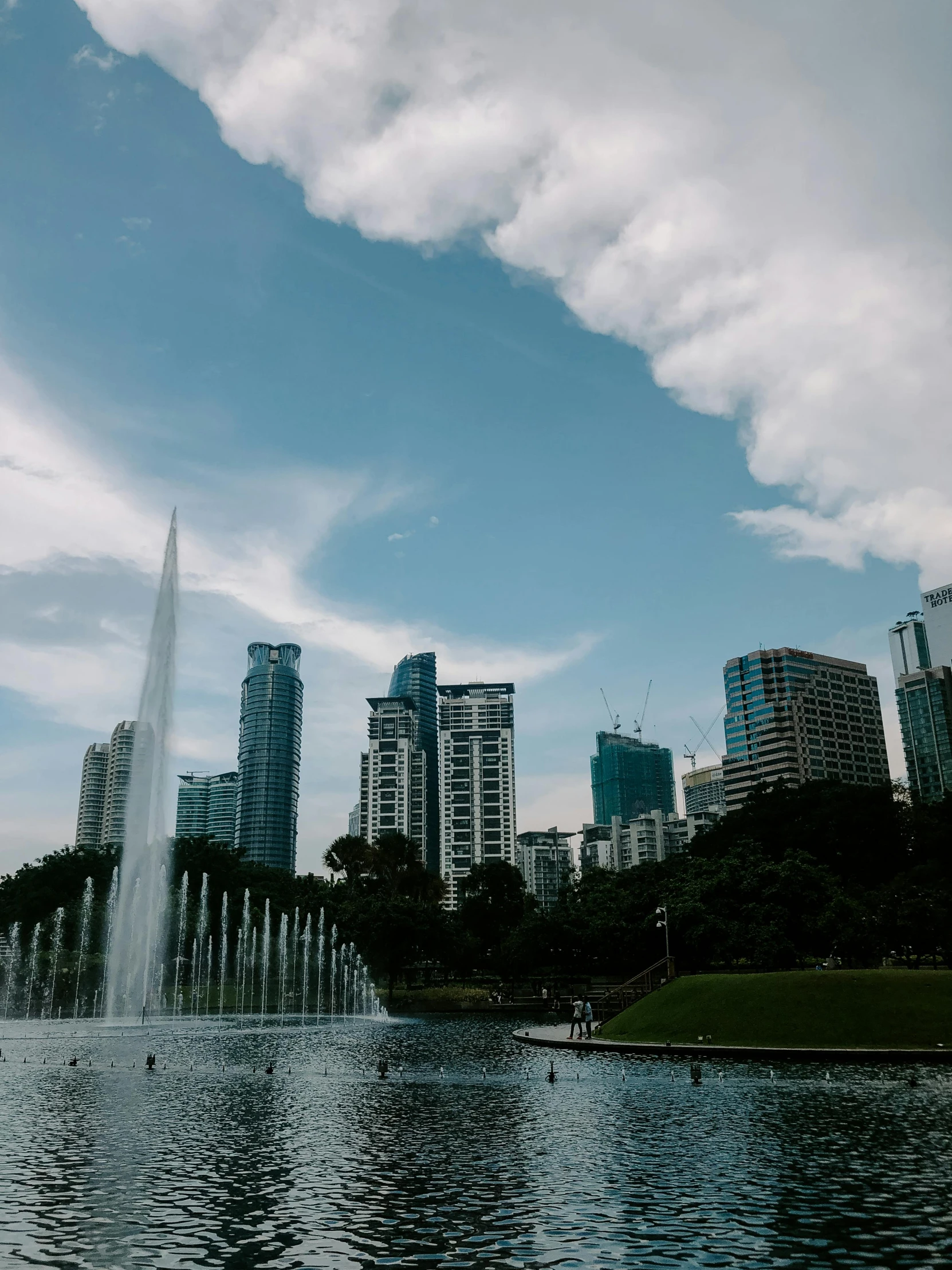 a large body of water surrounded by tall buildings, by Cherryl Fountain, pexels contest winner, hurufiyya, malaysian, in a city park, background image, #trending