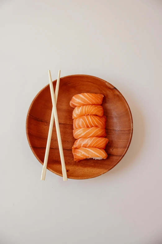 a wooden plate topped with sushi and chopsticks, inspired by Tōshi Yoshida, unsplash, purism, salmon, 2 1 0 mm, 6 pack, kami