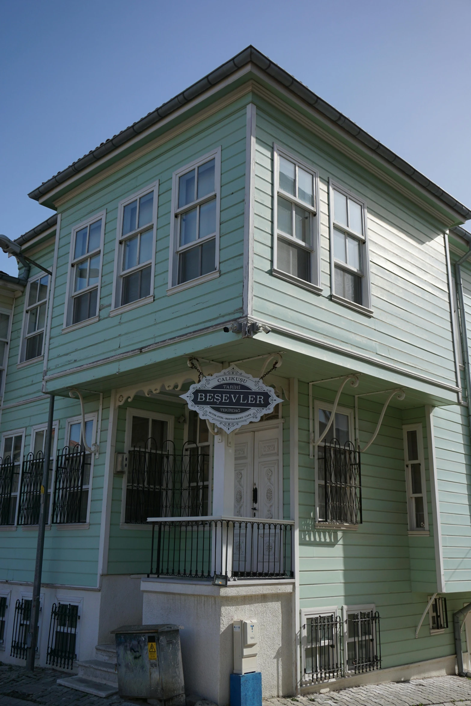 a green house sitting on the corner of a street, slide show, old west, exterior, restored