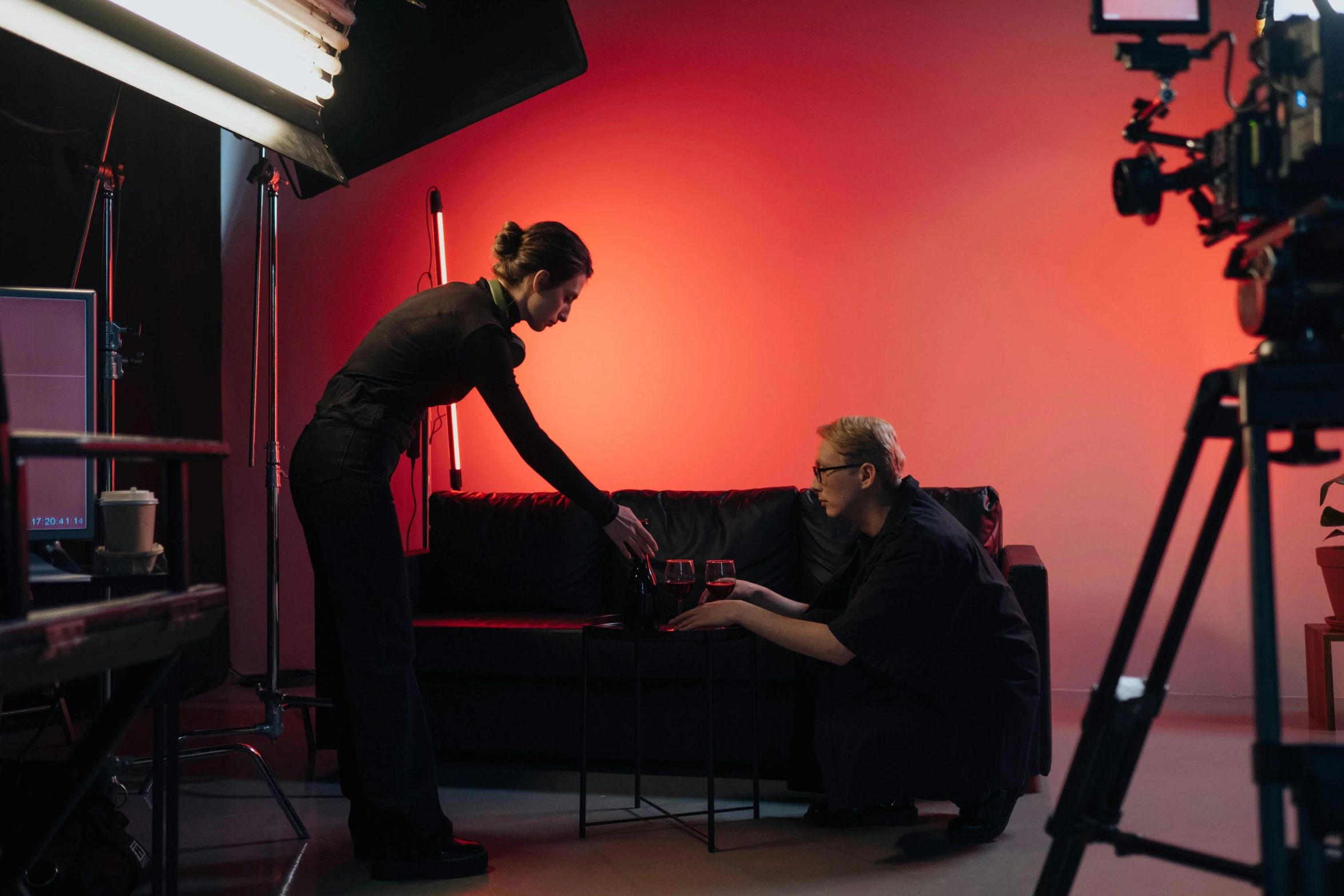 a woman standing next to a man on a couch, pexels contest winner, video art, product studio lighting, behind the scenes, red and cinematic lighting, shot from professional camera