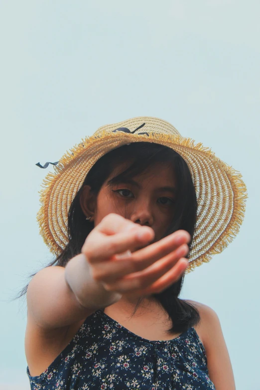 a close up of a person wearing a hat, by Arabella Rankin, unsplash, visual art, fighting stance, young asian girl, straw, holiday