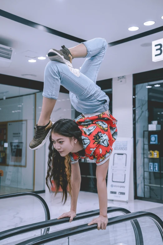 a woman doing a handstand on an escalator, by Jason Chan, wearing pants and a t-shirt, full body cute young lady, hong june hyung, photo taken in 2018