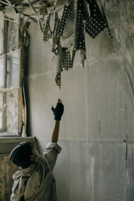 a man that is standing in front of a window, things hanging from ceiling, demolition, militaristic, ignant