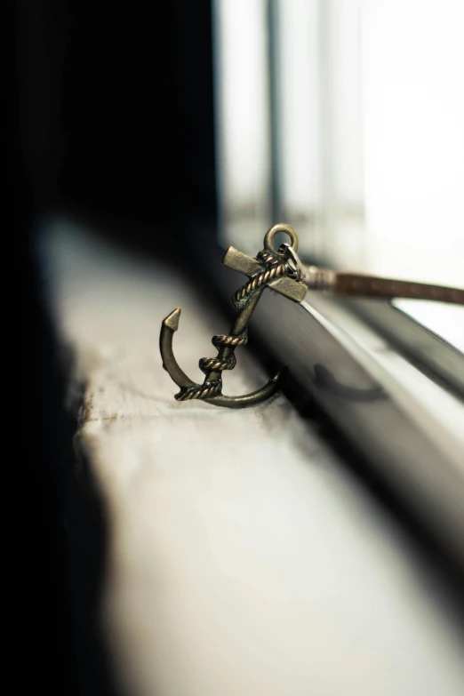 a pair of scissors sitting on top of a window sill, a tattoo, unsplash, anchor goatee, jewelry, moored, high dof