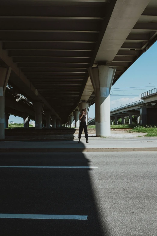 a person riding a skateboard under a bridge, a picture, unsplash, happening, standing in a parking lot, highway, in louisiana, shot on hasselblad