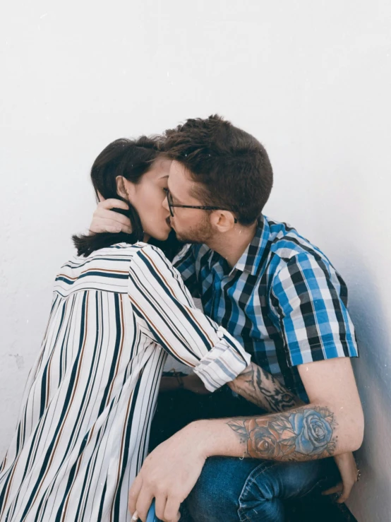 a man and a woman sitting next to each other, trending on pexels, lesbian kiss, striped, photograph of a sleeve tattoo, half body photo