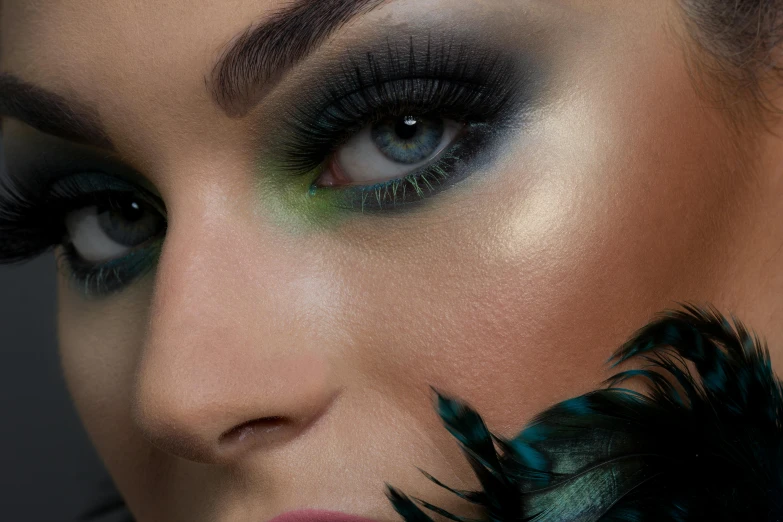 a close up of a woman with a feather on her head, inspired by Mac Conner, trending on cg society, dark green smokey eyeshadow, black cyan gold and aqua colors, makeup. unreal engine, trending on imagestation