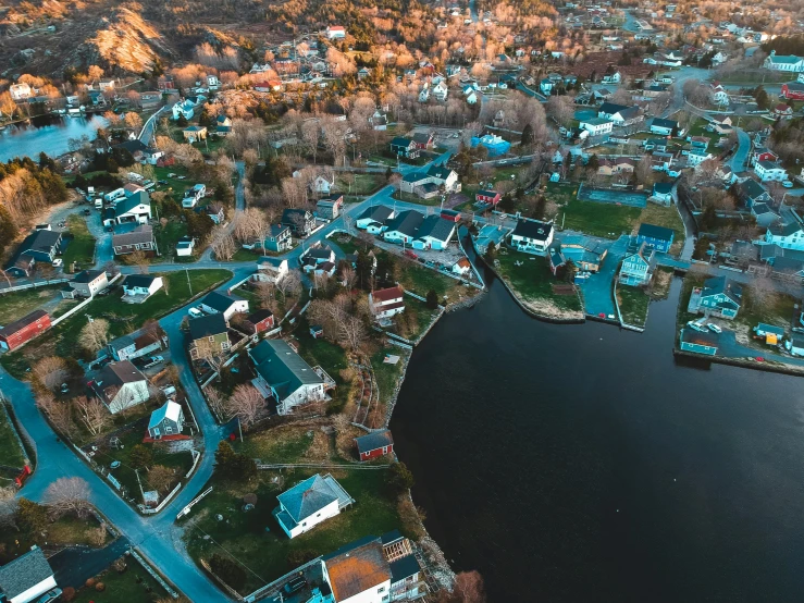 a large body of water surrounded by lots of houses, by Carey Morris, pexels contest winner, craigville, cinematic footage, high quality details, small town surrounding