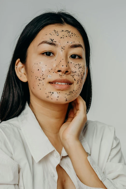 a woman with black spots on her face, trending on pexels, textured base ; product photos, asian, black tar particles, body and face