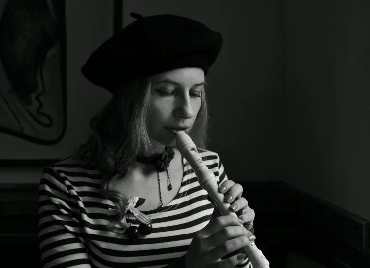 a black and white photo of a woman playing a flute, a black and white photo, inspired by François Barraud, antipodeans, wearing a french beret, high quality upload, homemade, portrait image