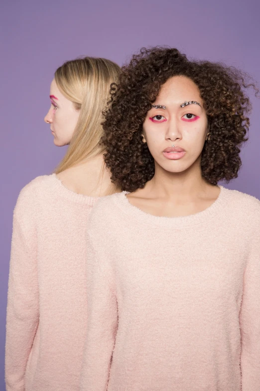 a couple of women standing next to each other, an album cover, inspired by Maud Naftel, trending on pexels, aestheticism, pink face, mixed race, intelligent eyes. symmetrical, coloured photo