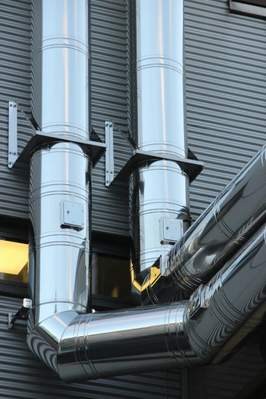 a couple of pipes that are on the side of a building, shiny and metallic, inlets, efficient, thumbnail