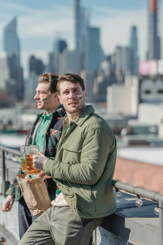 a couple of men sitting on top of a building, holding a mug of beer, new york backdrop, on a bridge, booze