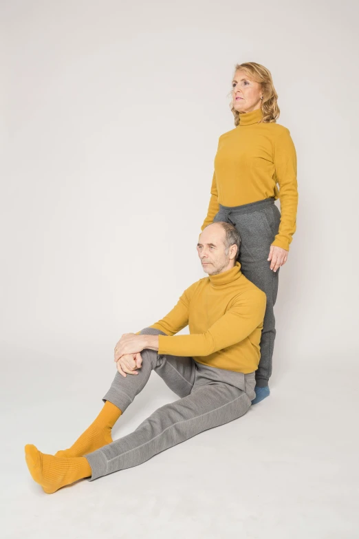 a man and a woman sitting next to each other, by Will Ellis, antipodeans, wearing turtleneck, yellow charcoal, standing on two legs, promo image