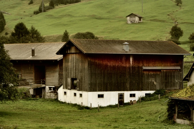 a barn sitting on top of a lush green hillside, by Werner Andermatt, pexels contest winner, renaissance, muted browns, panorama, 70s photo, ready to eat