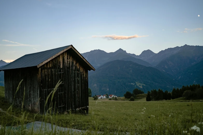 a small cabin in a field with mountains in the background, by Otto Meyer-Amden, pexels contest winner, renaissance, summer evening, shed roof, conde nast traveler photo, outside view