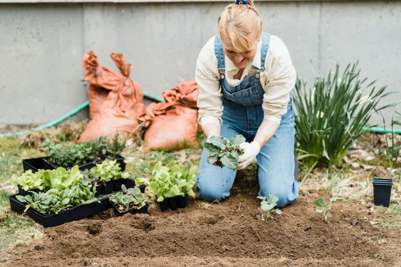 a woman that is kneeling down in the dirt, with a garden, profile image