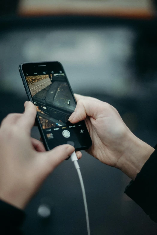 a close up of a person holding a cell phone, a picture, by Niko Henrichon, trending on pexels, happening, square, drone footage, with a black background, charging through city