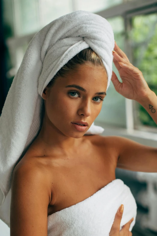 a woman with a towel wrapped around her head, inspired by Elsa Bleda, trending on pexels, :: madison beer, a blond, tattooed, spa