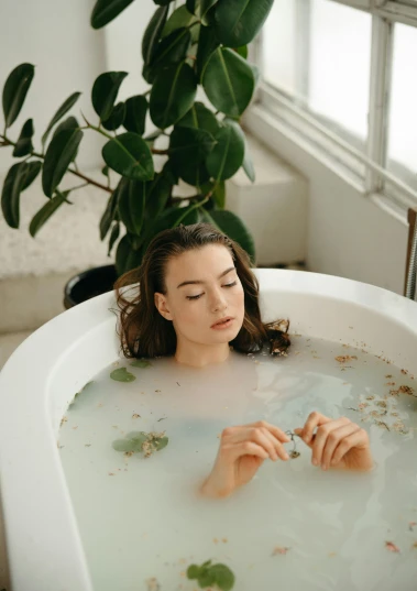 a woman taking a bath in a bathtub, inspired by Elsa Bleda, trending on pexels, renaissance, lush garden spaceship, sad look, resin, tall