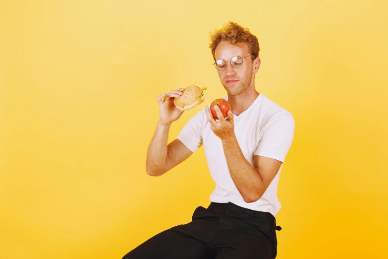 a man sitting on a stool eating an apple, by Lee Gatch, trending on pexels, yellow carrera glasses, golden ration, pale - skinned, joel fletcher