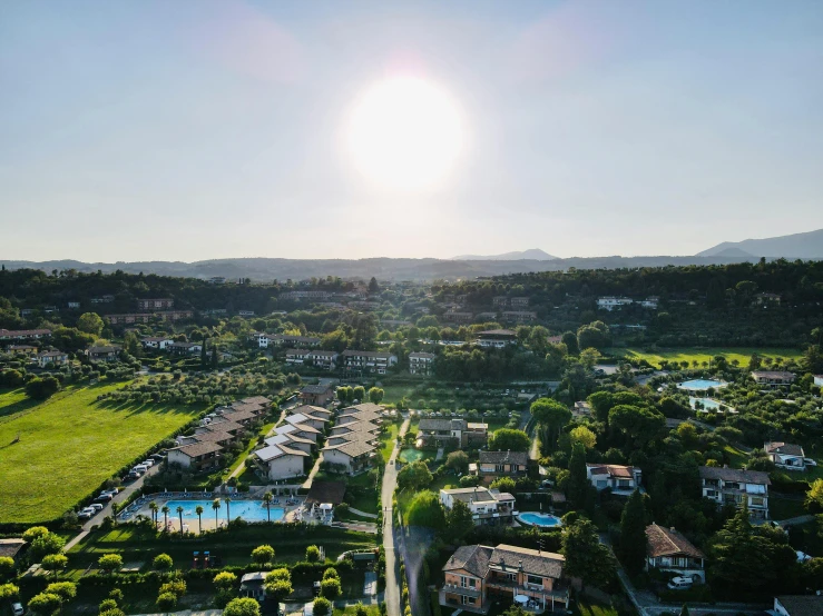 a bird's eye view of a golf course, pexels contest winner, large landscape with village, sun flares, southern european scenery, resort