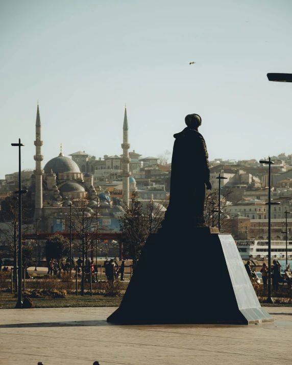 a statue of a man standing in front of a cityscape, pexels contest winner, hyperrealism, ottoman empire, woman in black robes, 🚿🗝📝, camel statue