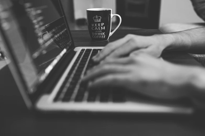 a close up of a person typing on a laptop, a black and white photo, by Romain brook, pexels, coffee cup, calm evening, avatar image, photorender