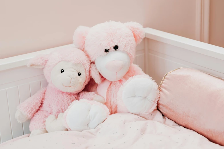 a couple of teddy bears sitting on top of a bed, by Emma Andijewska, pexels, pink color scheme, sheep, girl's room, high resolution product photo