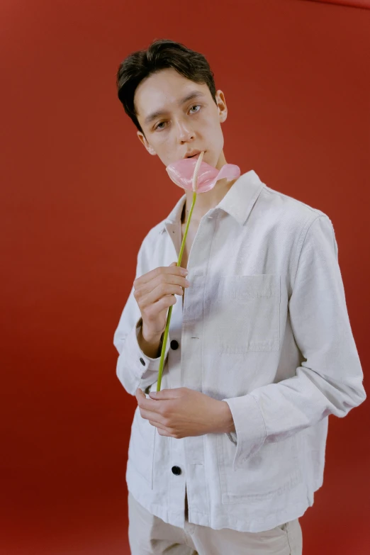 a man in a white shirt holding a pink flower, inspired by Russell Dongjun Lu, aestheticism, non binary model, with a straw, tommy 1 6 years old, pale red