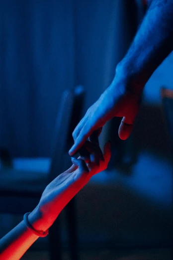 a close up of a person holding a child's hand, an album cover, inspired by Elsa Bleda, trending on reddit, red and blue black light, abduction, cinematic blue lighting, limbs