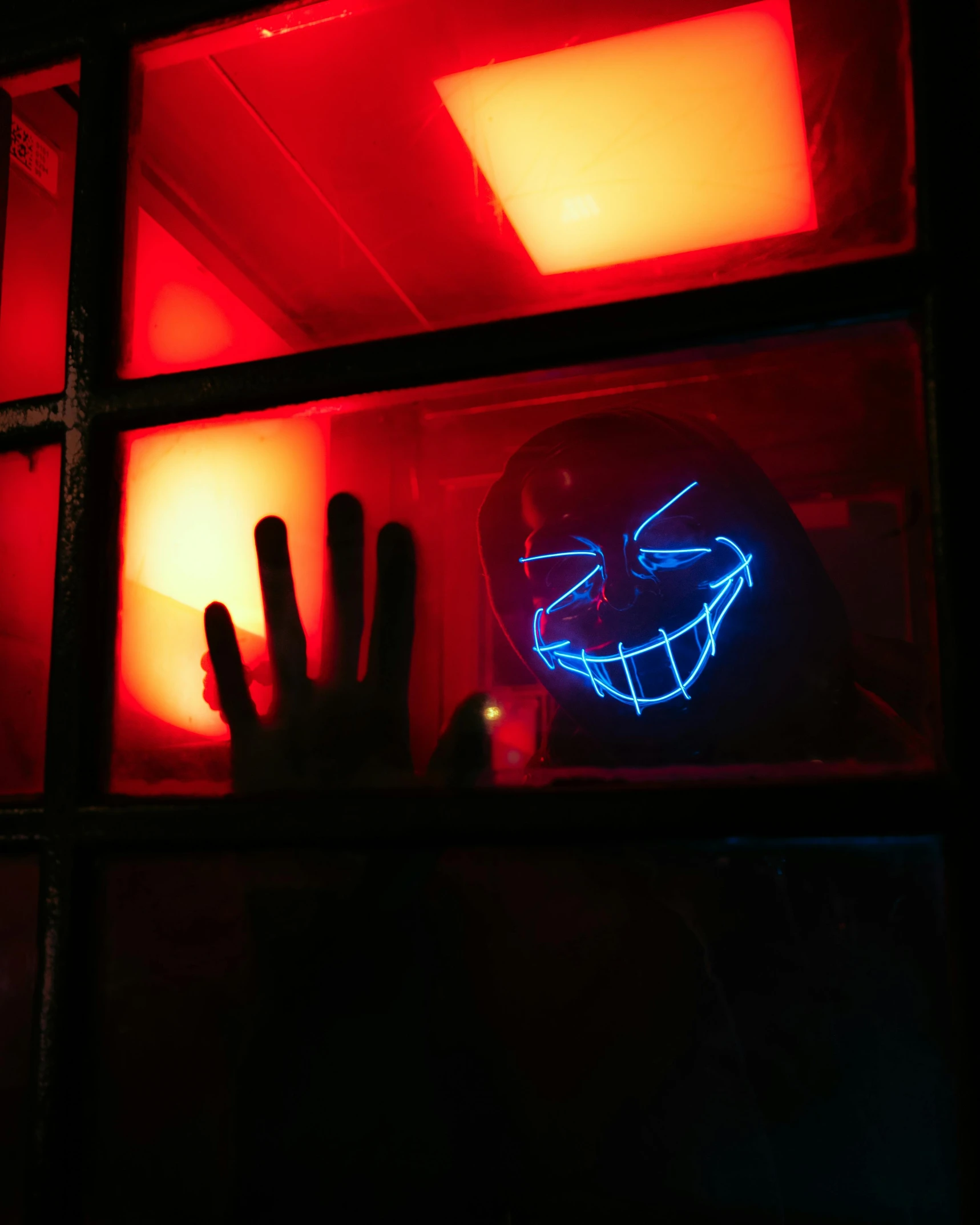 a close up of a neon sign in a window, a hologram, pexels contest winner, scary smile, holding his hands up to his face, villain wearing a red oni mask, wall darkness