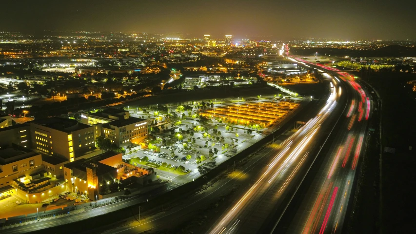 an aerial view of a city at night, by Brad Holland, unsplash contest winner, cupertino, parking lot, ultrawide lens”