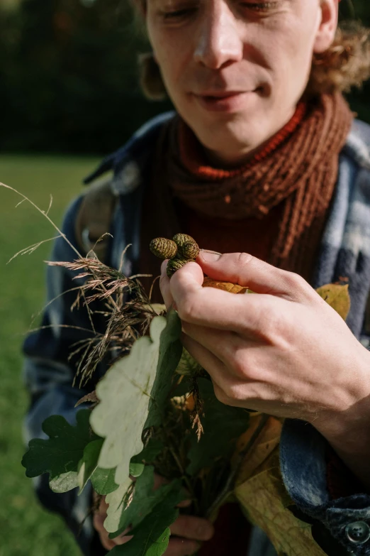 a close up of a person holding a plant, acorns, roots and hay coat, adventure, profile image