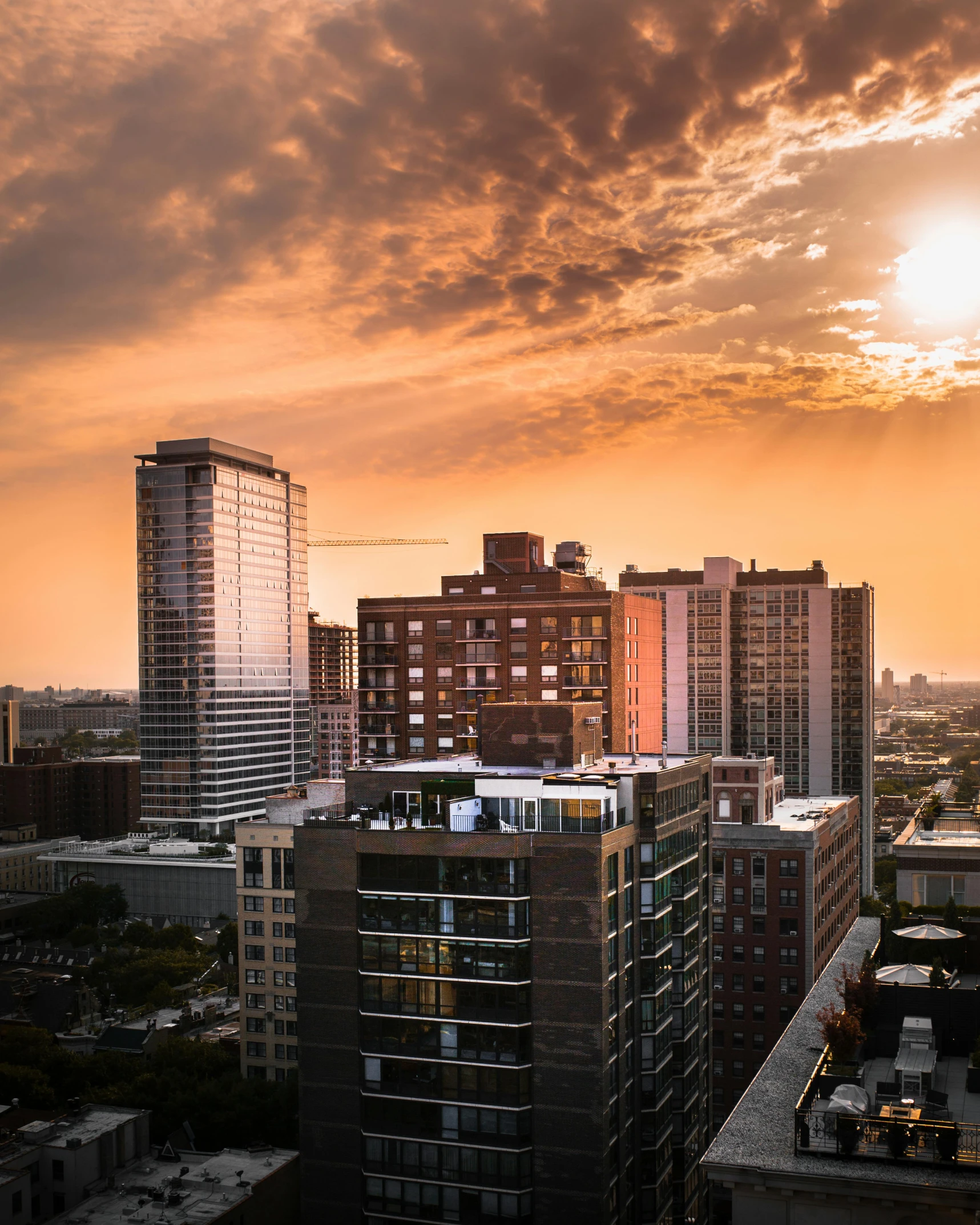the sun is setting over the city skyline, by Carey Morris, pexels contest winner, rooftop romantic, tyndall rays, wide high angle view, from wheaton illinois