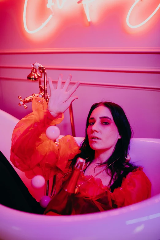 a woman sitting in a bathtub in front of a neon sign, an album cover, inspired by Elsa Bleda, trending on pexels, scarlet witch, with index finger, yael shelbia, mansion