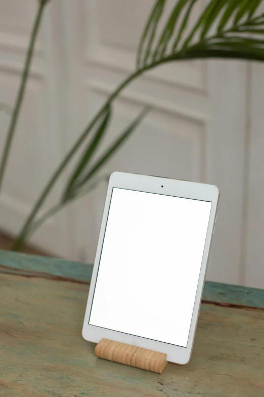 a tablet computer sitting on top of a wooden table, by Sven Erixson, unsplash, photorealism, square, white pearlescent, white, portrait of small