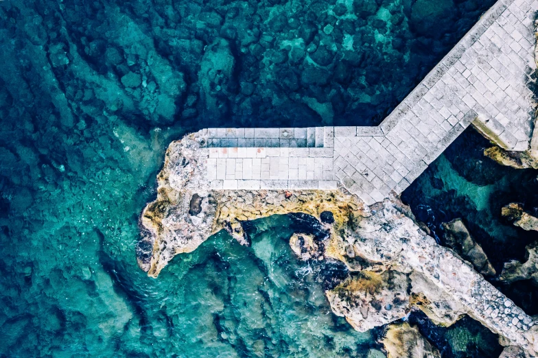 an aerial view of a bridge over a body of water, an album cover, by Simon Marmion, pexels contest winner, cyprus, near a jetty, reefs, 🦩🪐🐞👩🏻🦳