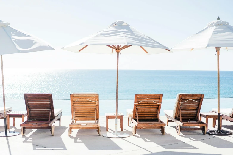 a group of lawn chairs and umbrellas on a beach, pexels contest winner, infinity pool, los angelos, crisp smooth clean lines, profile image