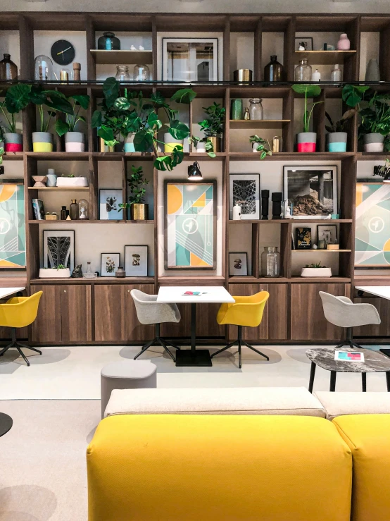 a living room filled with furniture and bookshelves, inspired by Albert Paris Gütersloh, unsplash, cafe tables, behance lemanoosh, yellow scheme, colorful modern