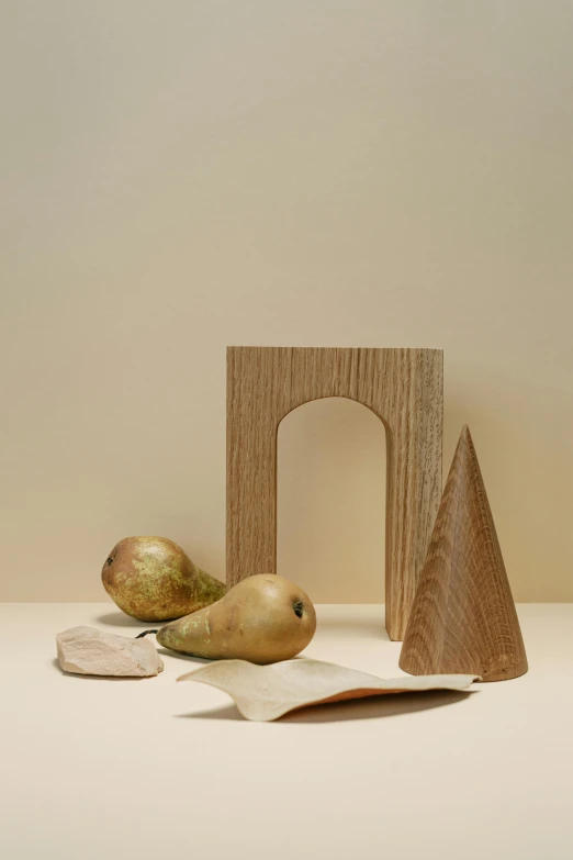 a couple of pears sitting on top of a table, an abstract sculpture, inspired by Isamu Noguchi, new sculpture, an archway, paper grain, oak, various sizes