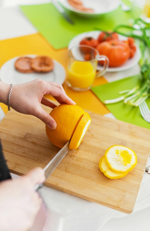 a person cutting an orange on a cutting board, by Sven Erixson, shutterstock contest winner, lemon demon, delightful surroundings, tabletop, fully functional