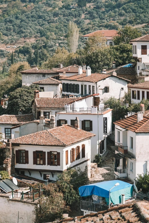 a group of houses sitting on top of a hill, white buildings with red roofs, turkey, lush surroundings, exterior shot