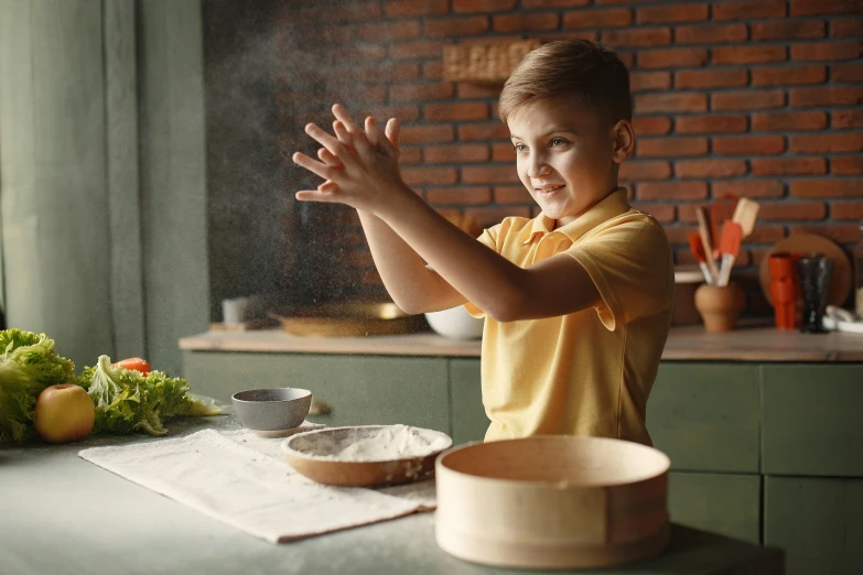 a little boy that is standing in front of a table, a picture, cooking, hands in the air, avatar image, pottery