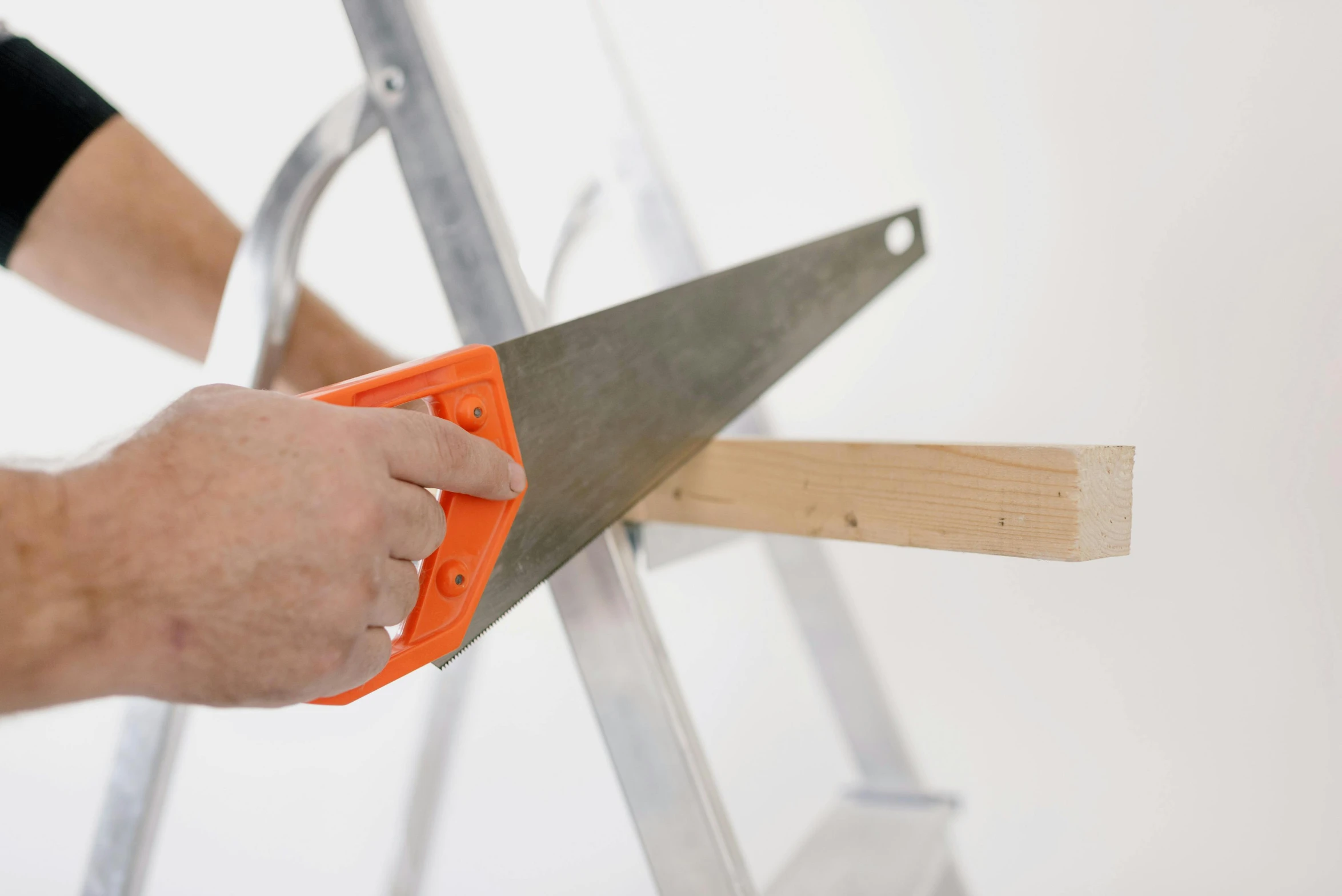 a person using a saw to cut a piece of wood, by Julian Allen, standing on a ladder, detailed product image, white wall coloured workshop, zoomed in