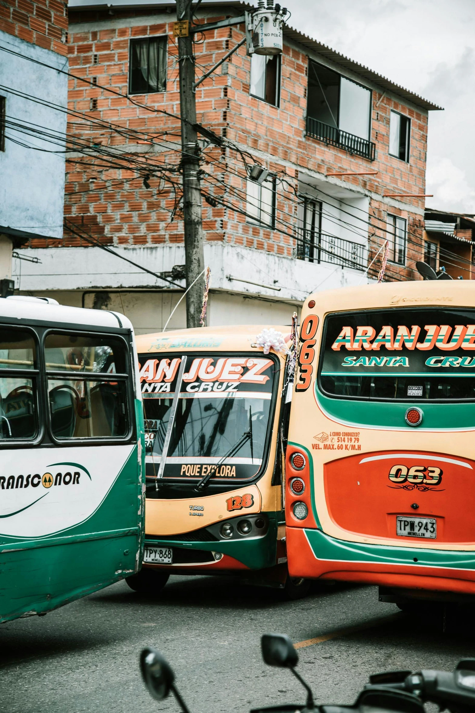 a group of buses parked next to each other on a street, by Gina Pellón, colombian, 🚿🗝📝