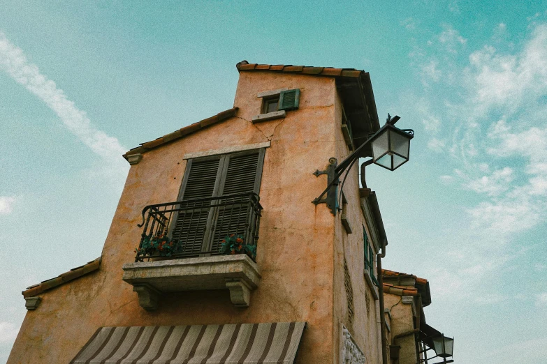 a tall building with a balcony and a balcony, an album cover, pexels contest winner, neoclassicism, french village exterior, brown and cyan color scheme, unsplash photography, multiple stories