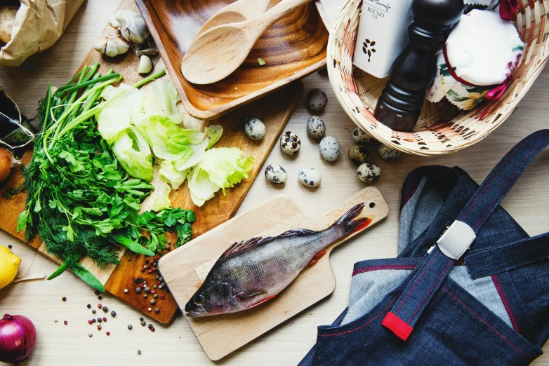 a wooden cutting board topped with lots of food, a picture, by Julia Pishtar, unsplash, renaissance, fish man, 9 9 designs, salad, filleting technique