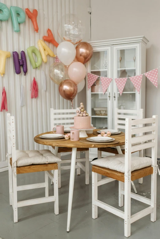 a table and chairs in a room with balloons, white and pink, lifestyle, thumbnail, bakery