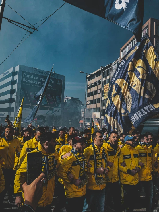 a group of people in yellow jackets holding flags, pexels contest winner, happening, soccer, photo of zurich, gritty image, 🚿🗝📝